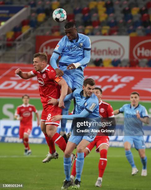 Rouwen Hennings of Duesseldorf is challenged by Armel Bella-Kotchap and Maxim Leitsch of Bochum during the Second Bundesliga match between Fortuna...