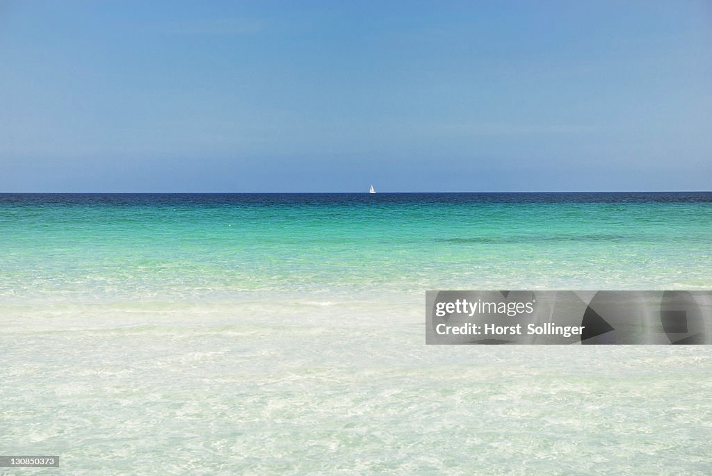 Horizon with sailing ship, turquoise sea with sandy beach, La Cinta, Sardinia, Italy, Europe