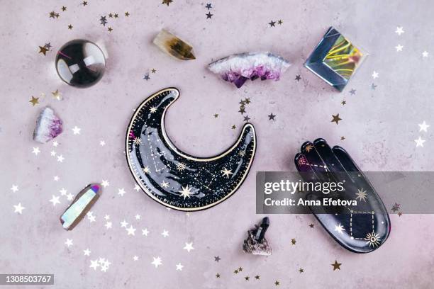 magic crystals for rituals. esoteric set with many tools on concrete gray background with silver and gold stars sequins. flat lay style - amethyst stock-fotos und bilder