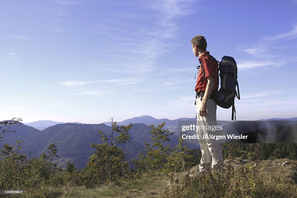 Hiker looking into the valley on Mt. Leder Tschobenstein in Bernau in the Black Forest, Baden-Wuerttemberg, Germany, Europe