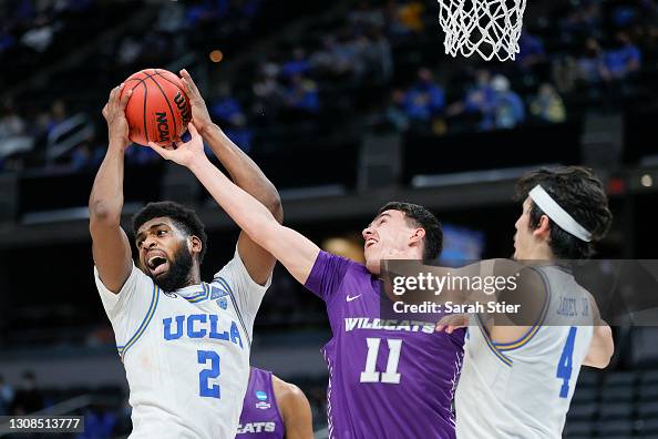 Cody Riley Cody Riley of the UCLA Bruins looks to pass defended by Tobias... News ...