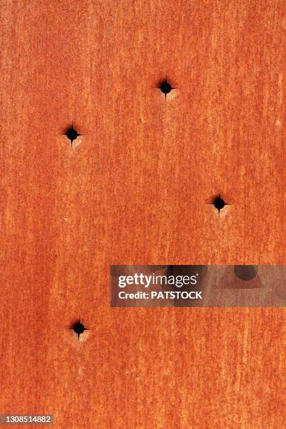 bullet holes design in corrugated metal surface. - bullet holes stock pictures, royalty-free photos & images