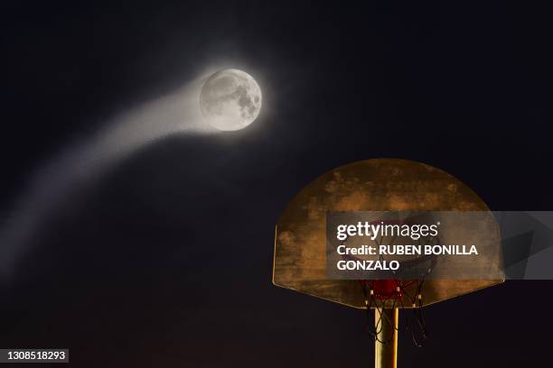 moon ball playing basketball falling in basketball hoop during night - moon shot photos et images de collection