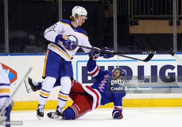 Rasmus Dahlin of the Buffalo Sabres checks Kevin Rooney of the New York Rangers during the second period at Madison Square Garden on March 22, 2021...