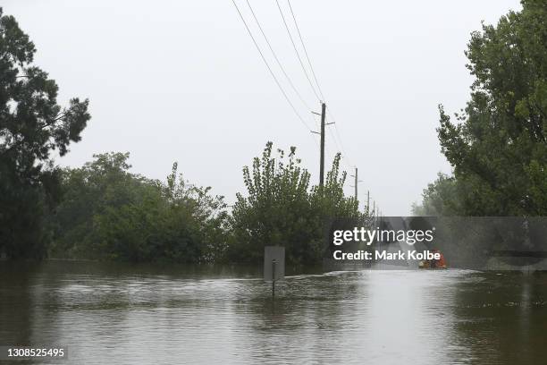 State Emergency Service workers drive their rescue craft through the flooded Hawkesbury river along Inalls lane in Richmond on March 23, 2021 in...