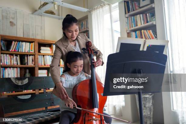 little girl having cello lesson with music teacher - girl cello stock pictures, royalty-free photos & images