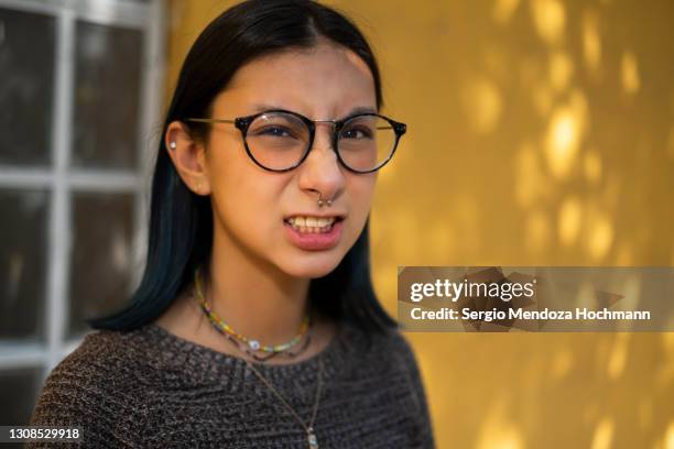 young hispanic woman angrily looking at the camera - black hair stockfoto's en -beelden