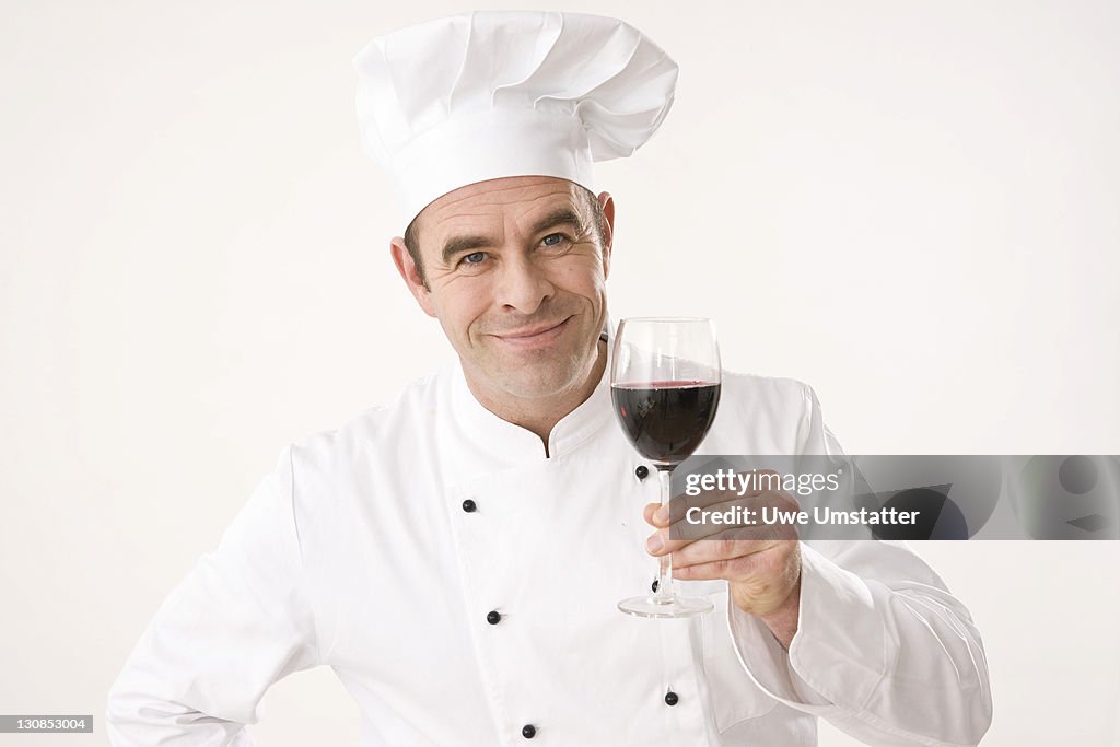 Cook holding a glass of red wine