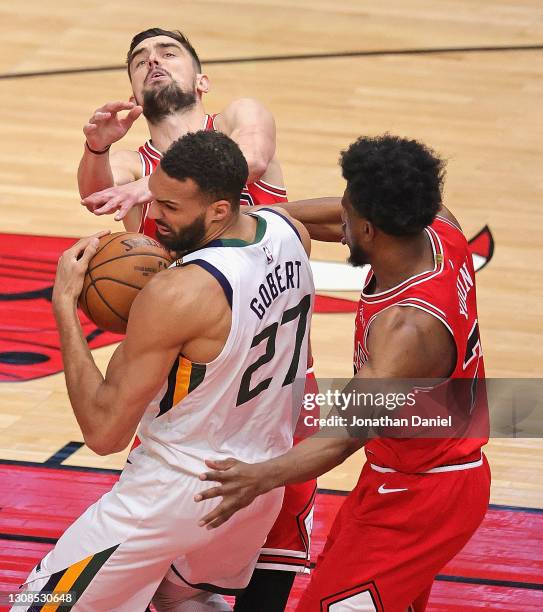 Rudy Gobert of the Utah Jazz rebounds between Tomas Satoransky and Thaddeus Young of the Chicago Bulls at the United Center on March 22, 2021 in...