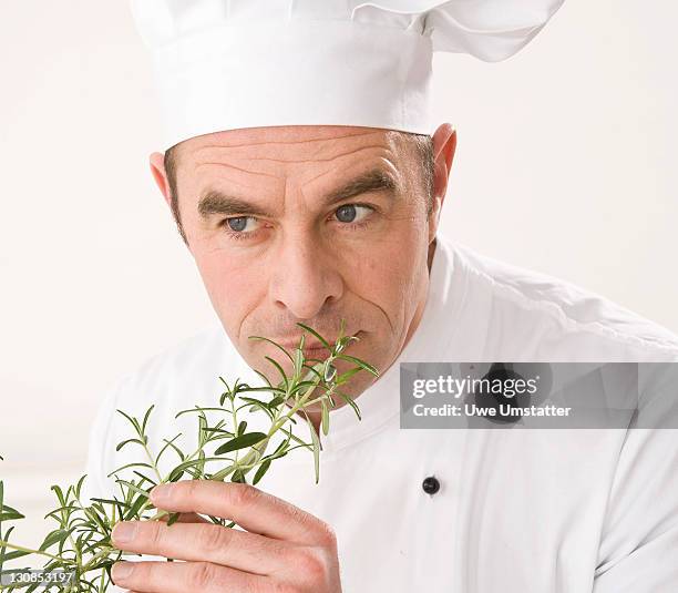 cook smelling a branch of rosemary - old person kitchen food ストックフォトと画像