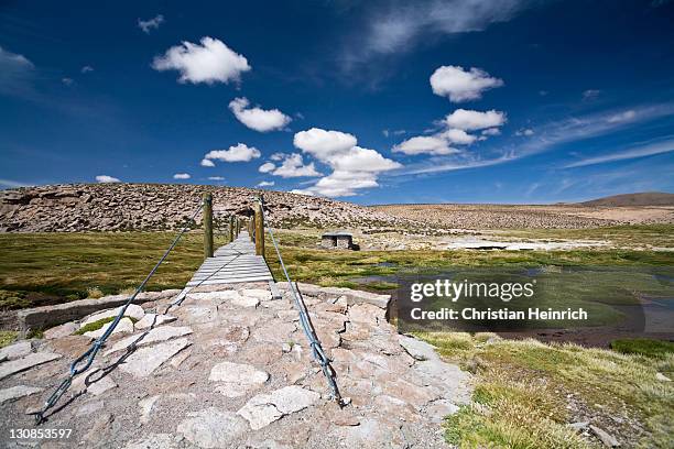 mountain landscape with rope bridge and hot springs on the way from the conaf station las cuevas, national park lauca, chile, south america - southernly stock pictures, royalty-free photos & images