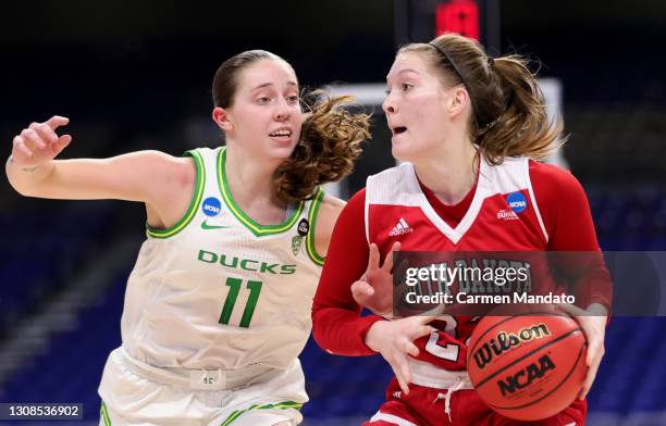 Chloe Lamb of the South Dakota Coyotes is guarded by Taylor Mikesell of the Oregon Ducks during the first half in the first round game of the 2021...