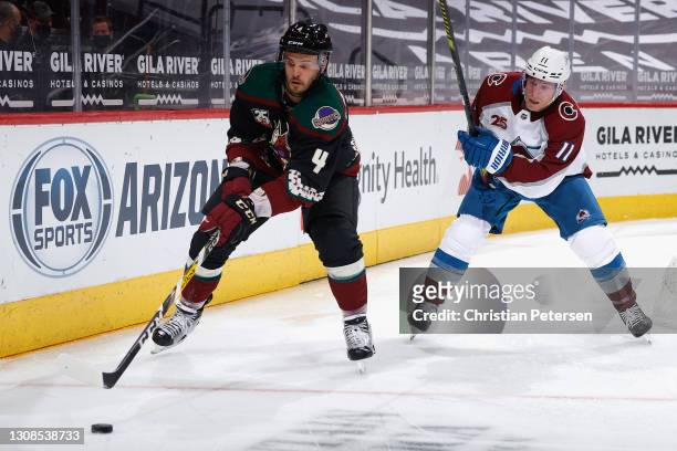 Niklas Hjalmarsson of the Arizona Coyotes skates with the puck ahead of Matt Calvert of the Colorado Avalanche during the second period of the NHL...