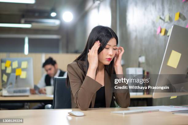 young tired working woman at work - astigmatism stock-fotos und bilder