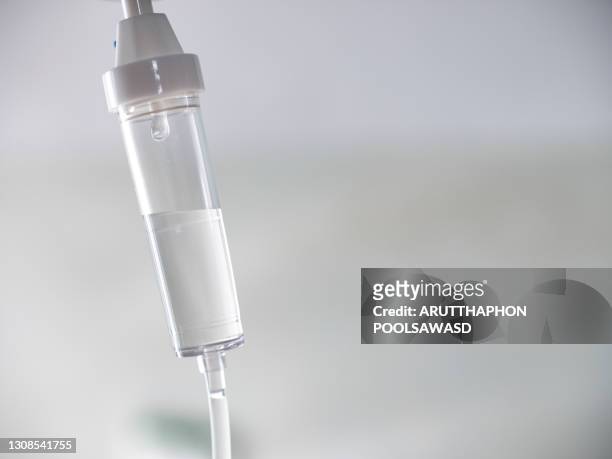 close up on tube of iv chemical pharmaceutical liquid - infused - fotografias e filmes do acervo