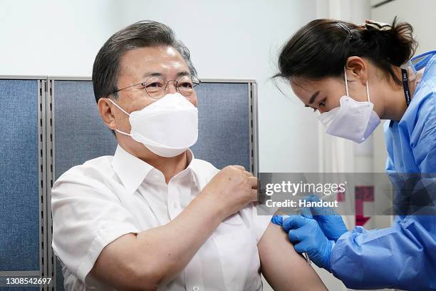 In this handout image provided by South Korean Presidential Blue House, South Korean President Moon Jae-in receives a dose of the AstraZeneca...