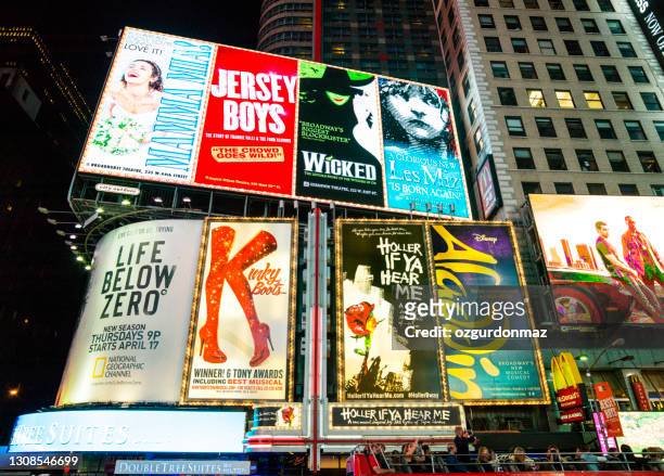 electronic billboards in times square new york advertising theatre shows are displayed on the buildings along 7th avenue - broadway theater exteriors and landmarks stock pictures, royalty-free photos & images