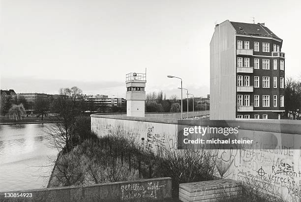 view over the berlin wall in 1985, detached house next to a watchtower adjacent to the inner german border, known as the death strip, berlin, germany, europe - catchwords foto e immagini stock