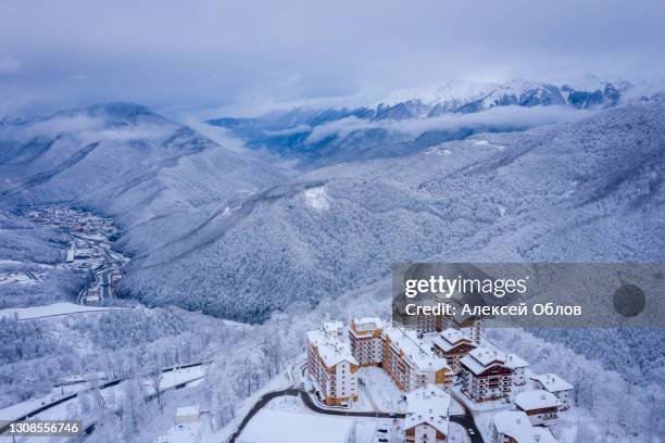 winter aerial view of the ski resort rosa khutor. a complex of hotels on the site of the former olympic village of rosa plateau at an altitude of 1170 m from sea level. krasnaya polyana, sochi, russia - sotsji stockfoto's en -beelden