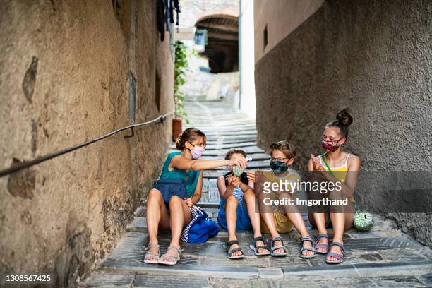 la famiglia visita una bellissima città italiana durante la pandemia di covid-19 - gel foto e immagini stock