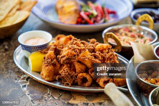 calamari frito servido en buffet con limón y salsa de inmersión en plato de plata ovalada - freír mediante inmersión total en aceite caliente fotografías e imágenes de stock