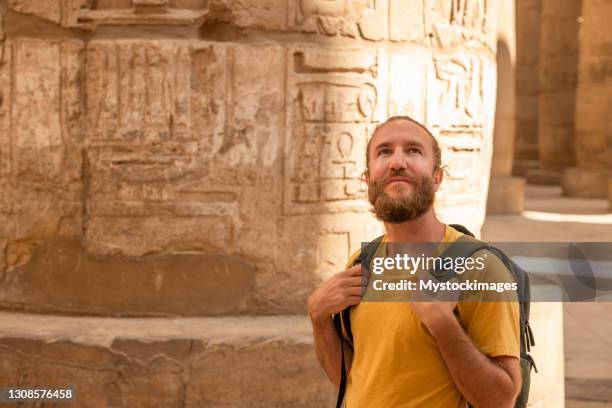 young male traveller wandering through ancient karnak temple - egypt tourist stock pictures, royalty-free photos & images