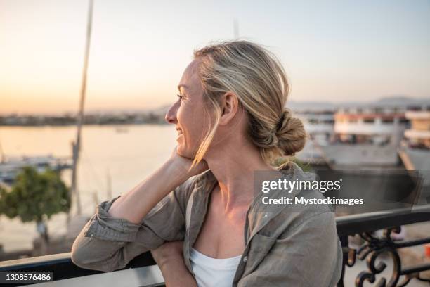 serene frau genießt den sonnenuntergang vom nilufer - nile river stock-fotos und bilder