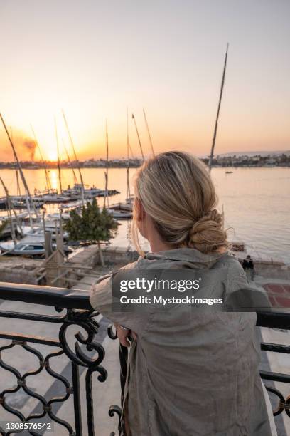 rear view of woman contemplating the nile at sunset - river nile stock pictures, royalty-free photos & images