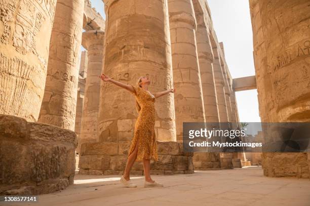 woman enjoying her visit in karnak temple in luxor - royalty free stock pictures, royalty-free photos & images