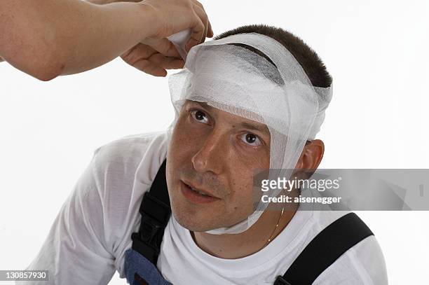manâ´s head being bandaged, dressed - head bandage stock-fotos und bilder