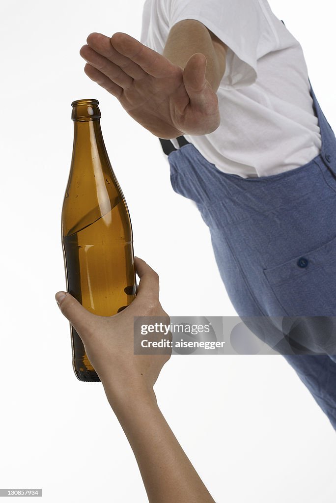 Workman, construction worker rejecting a bottle of beer being offered to him
