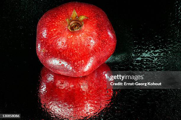 red apple on black background - granatapfel stockfoto's en -beelden