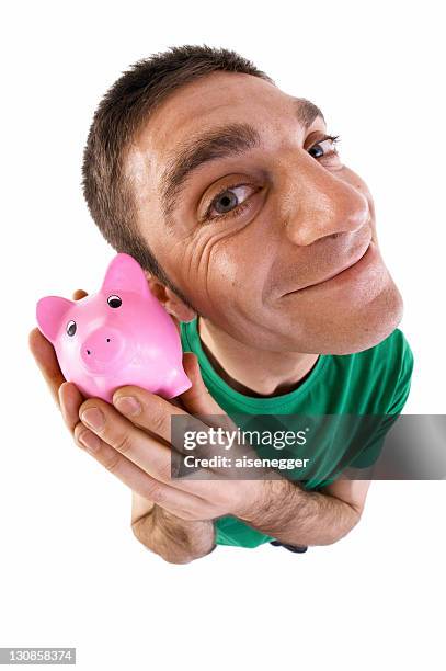 man holding a piggy bank to his ear, fish-eye lens - fish eye lens stockfoto's en -beelden