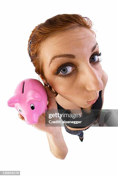 woman holding a piggy bank to her ear, fish-eye lens - fish eye lens stockfoto's en -beelden