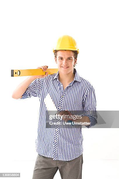 trainee wearing a hard hat, with a water level and a trowel - boy in hard hat photos et images de collection