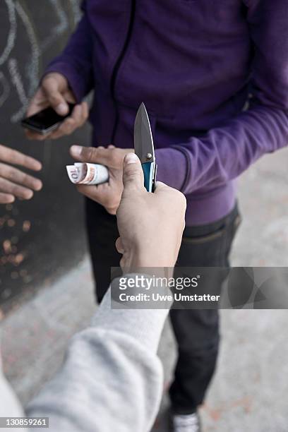 boy threatening with a knife, wanting money and mobile phone - time robber fotografías e imágenes de stock