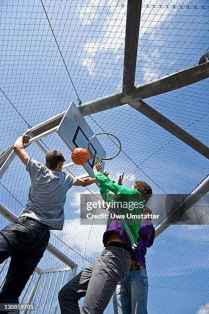 three boys playing basketball - angle photos et images de collection