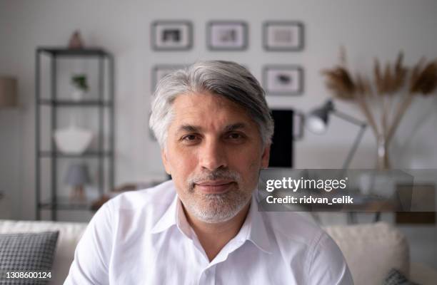 uomo d'affari che effettua videochiamata, guarda la telecamera e parla - studio head shot serious confident looking at camera foto e immagini stock