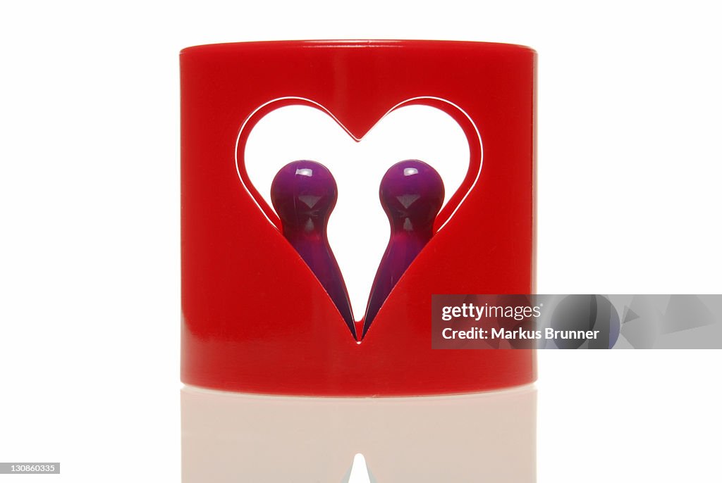 Two game pieces in ring with heart cut-out, symbolic for a couple