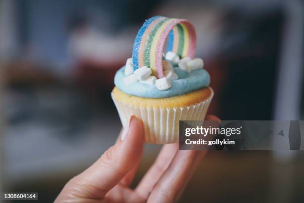 mujer sosteniendo unos cupcakes arco iris caseros - cupcake holder fotografías e imágenes de stock