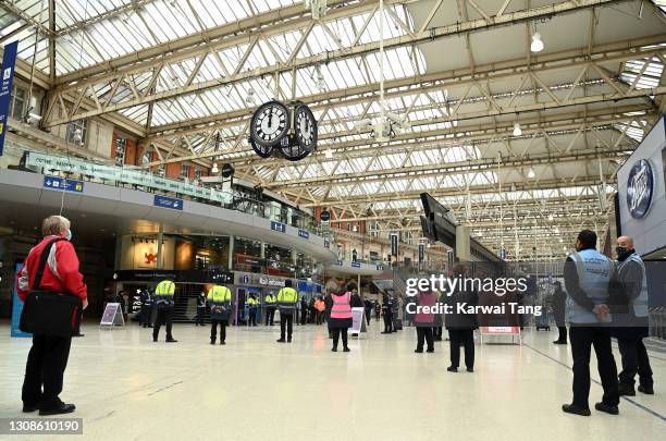 Commuters and employees take part in a one minute silence on the first anniversary of the first national Covid-19 lockdown at Waterloo train station...