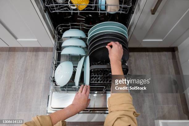 synvinkel av en kvinna som tömmer diskmaskinen - washing dishes bildbanksfoton och bilder