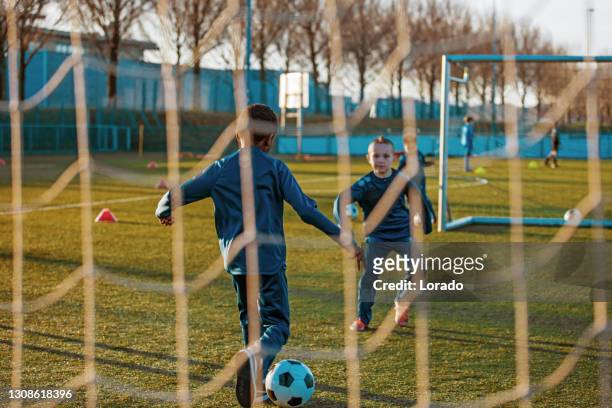 a small group of young boys and their coach training on the football pitch - practicing stock pictures, royalty-free photos & images
