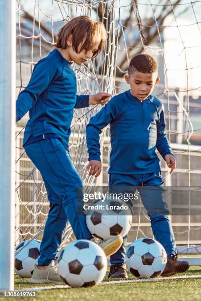 two young boys training hard on the football pitch - pro challenge stage 6 stock pictures, royalty-free photos & images