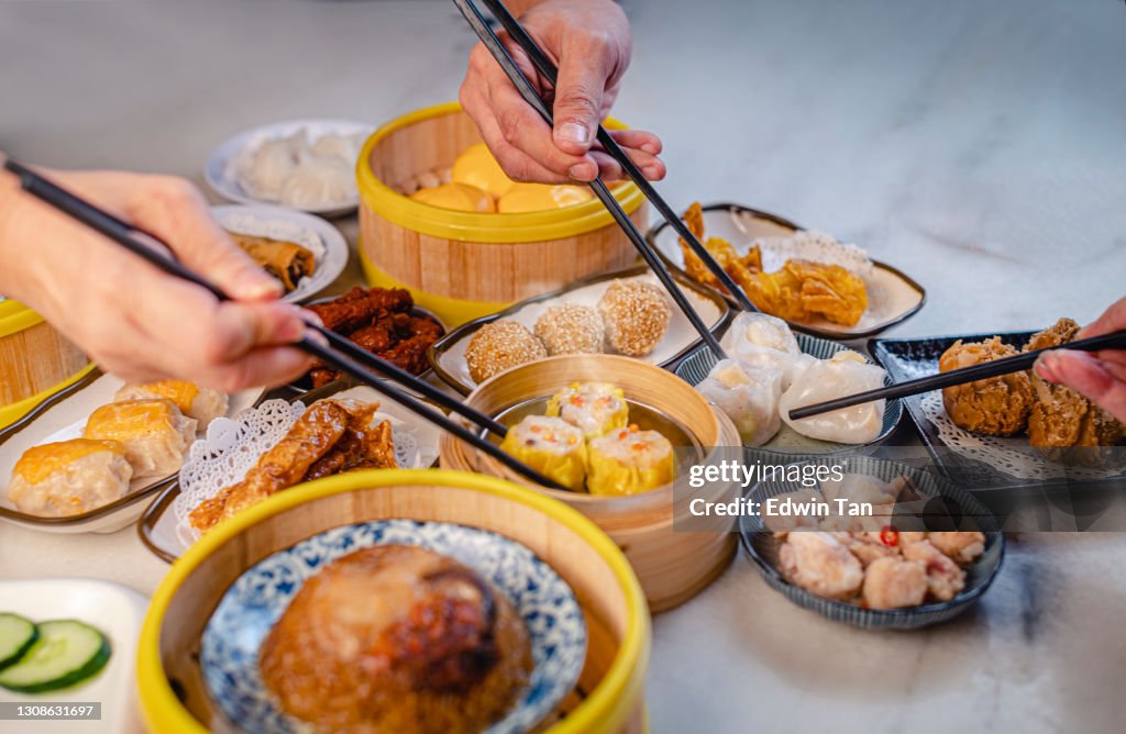 Human hand using chopstick picking up tradition chinese food dim sum
