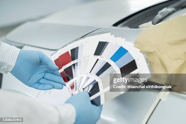 cropped image of technician hand matching a color of a car using color samples in a painting booth. - karosseriarbete bildbanksfoton och bilder