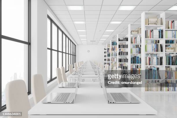 modern library with laptops on the table and books on the bookshelves. - literature stock pictures, royalty-free photos & images