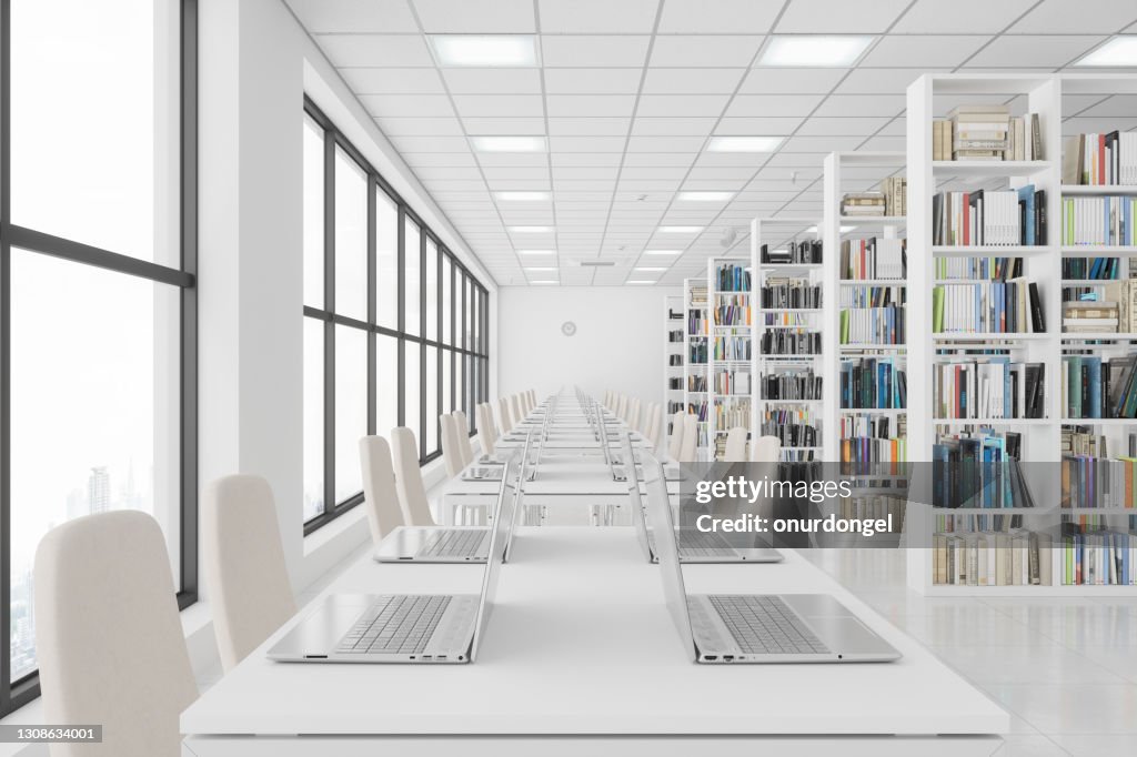 Modern Library With Laptops On The Table And Books On The Bookshelves.