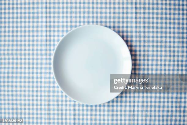 blue plate on a checkered blue-white fabric. - high section bildbanksfoton och bilder