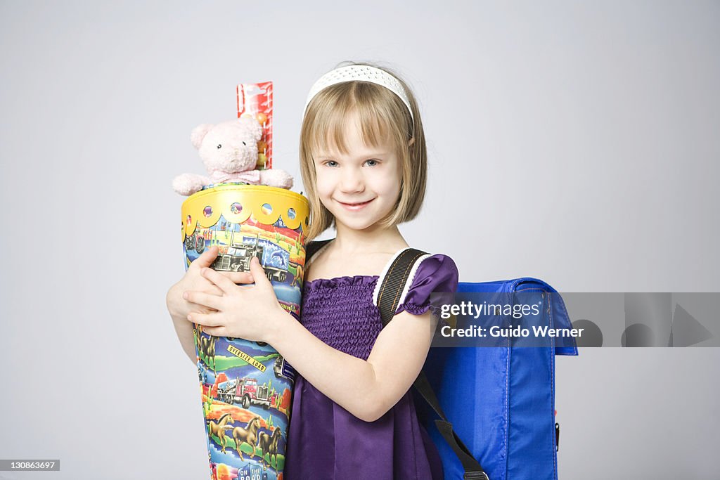 Girl holding a large cornet of cardboard filled with sweets and little presents given to children in Germany on their first day at school